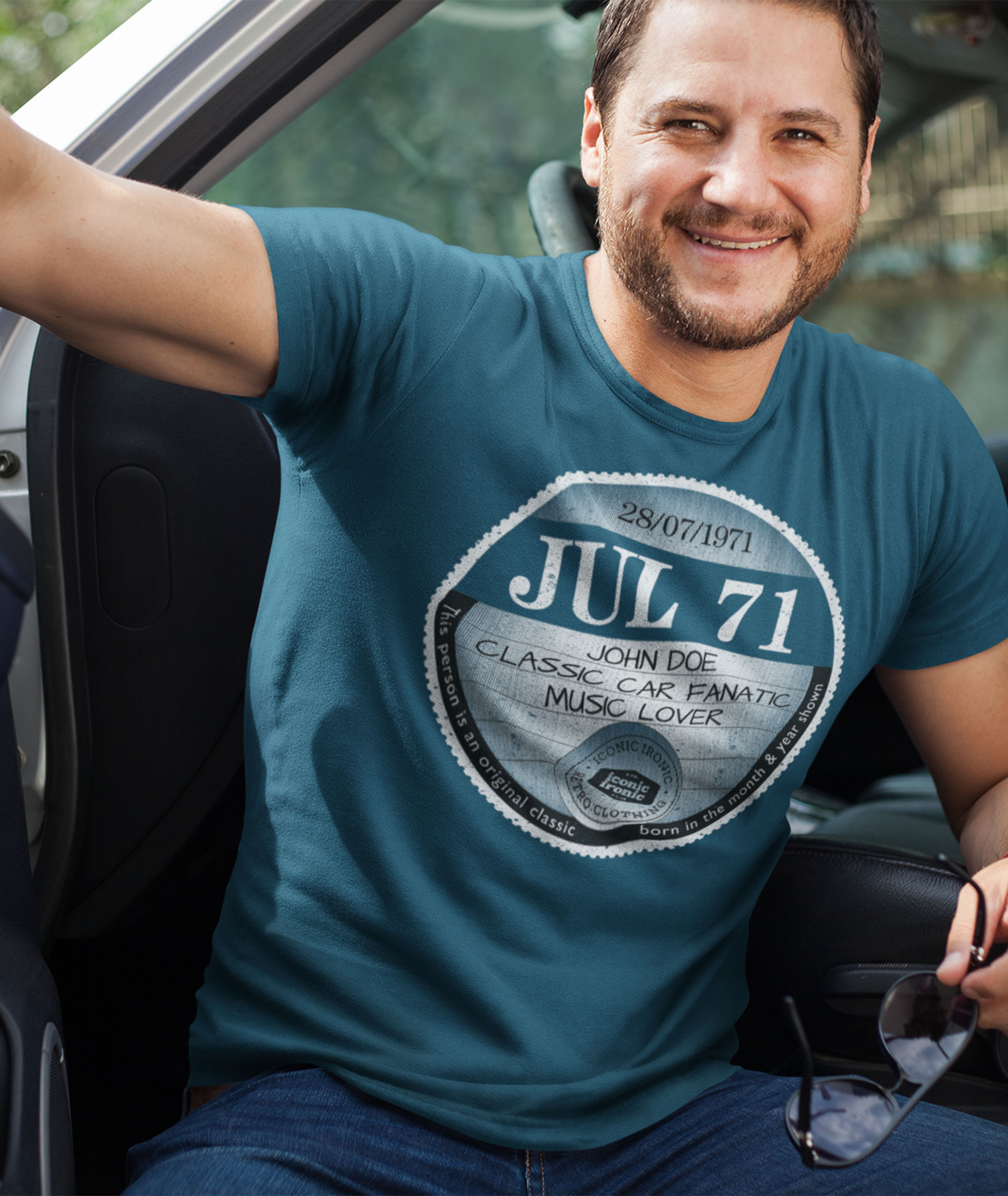Man in car wearing indigo large tax disc graphic t shirt